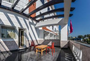 西里古里的住宿－Hotel Suktara International，大楼阳台上的桌椅