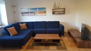 a living room with a blue couch and a coffee table at Ferienwohnung Waterkant in Kappeler Niederstrich