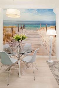 a dining room with a table and a boardwalk to the beach at INMálaga Palacio in Málaga