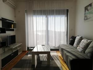a living room with a couch and a table and a window at Apartment Olive Montenegro KO Becici in Budva