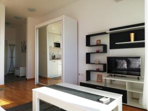 a living room with a white bench and a tv at Apartment Olive Montenegro KO Becici in Budva