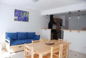 a living room with a table and a blue couch at Les Gîtes du Pla de Moura in Luz-Saint-Sauveur +7 photos