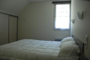 a white bed in a room with a window at Les Gîtes du Pla de Moura in Luz-Saint-Sauveur