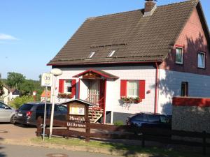 Biały i czerwony dom z czarnym dachem w obiekcie Harmonie Hotel Rust w mieście Hohegeiß