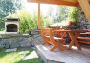 einem Picknicktisch und einer Bank auf einer Terrasse mit einem Kamin in der Unterkunft Haus Dorothee in Sautens