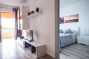 1 dormitorio con 1 cama y escritorio con ordenador en Apartamentos en Torres del Sol, en Arona