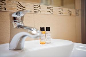 a bathroom sink with two bottles ofodorizers on it at Apartamenty Retro in Poznań +45 photos