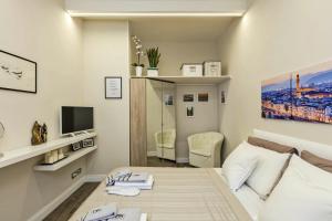 a white room with a bed and a tv at Little Suite Fortezza in Florence