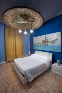 ein Schlafzimmer mit einem großen Bett und einer blauen Wand in der Unterkunft Marini Bed&Breakfast in Pescara