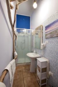 bagno blu con lavandino e doccia di Marini Bed&Breakfast a Pescara