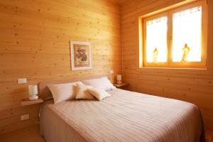 um quarto com uma cama num chalé de madeira em Il Rifugio dell'Aquila em Ligonchio