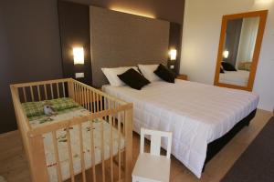 a bedroom with a bed and a crib and a mirror at Il Rifugio dell'Aquila in Ligonchio