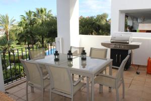 La Concha Vista La Quinta في مربلة: طاولة بيضاء وكراسي على فناء مع شواية