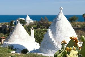two white structures with a cross on top of it at case per vacanze torre incina in Polignano a Mare