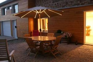 a table and chairs with an umbrella on a patio at Le Limonadier in Prunière