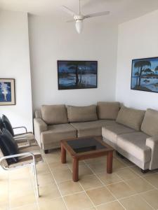 a living room with a couch and a coffee table at Apartamento Guaruja Pitangueiras in Guarujá