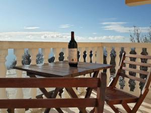 a bottle of wine sitting on a wooden table on a balcony at House Stijepovic in Petrovac na Moru
