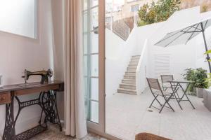 a room with a desk and a table and chairs at Graça Garden Home in Lisbon