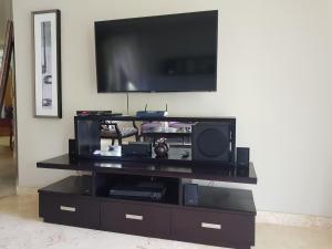 um centro de entretenimento preto com uma televisão de ecrã plano na parede em Luxury Oceanview Condo 2 BR/2.5 BA em Sosúa
