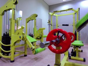 a gym with yellow and green equipment with a red apparatus at Bonno Hotel Paulínia in Paulínia