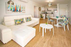een woonkamer met een witte bank en een tafel bij Flower Beach Suite 23 in Playa Honda