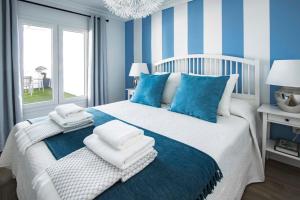 een blauwe en witte slaapkamer met een bed met handdoeken erop bij Flower Beach Suite 23 in Playa Honda +26 foto's