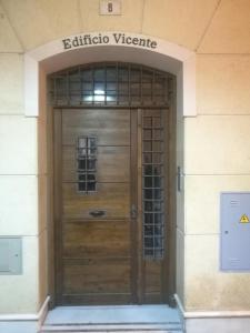 マラガにあるApartamentos Edificio Vicenteの看板の木製ドア