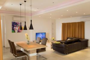 Suncity Hotel Apartment في آكرا: غرفة طعام وغرفة معيشة مع طاولة وأريكة