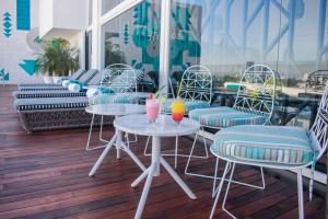 - deux tables et des chaises avec des boissons sur la terrasse dans l'établissement Square Small Luxury Hotel - Providencia, à Guadalajara