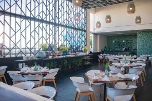 a dining room with tables and chairs and a window at Square Small Luxury Hotel - Nuevo Consulado in Guadalajara