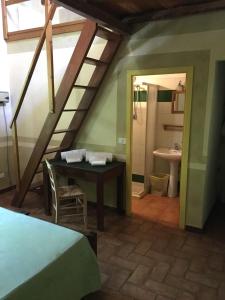 a attic room with a table and a bathroom with a sink at Agriturismo Cascina degli Ulivi in Novi Ligure