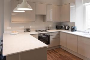 a kitchen with white cabinets and a counter top at Barclay House in Kelso