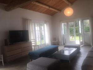 Una sala de estar con un sofá y un televisor. en Les Genets, en Ker borny