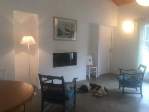 Un perro tumbado en el suelo de una sala de estar. en Les Genets, en Ker borny 2 fotos más