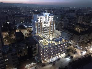 a tall white building with lights on top of it at Xheko Imperial Luxury Hotel & SPA in Tirana