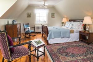 1 dormitorio con 1 cama y 1 silla en Idlwilde Inn, en Watkins Glen