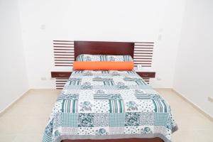 a bedroom with a bed with a blue and white quilt at Gran Hotel Marien in Sabaneta