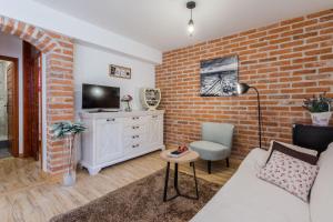 a living room with a brick wall at Apartments Rensi in Zadar