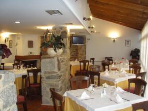 um restaurante com mesas e cadeiras num quarto em Pension Rustica-Caldelas Sacra em Castro Caldelas
