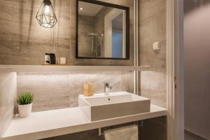 La salle de bains est pourvue d'un lavabo blanc et d'un miroir. dans l'établissement Chic and Cosy Flat in Plaka by UPSTREET, à Athènes