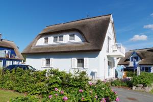 a white house with a thatched roof at Reethaus Meridian in Breege