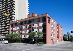 a red brick building on a street with two tall buildings at Canterra Suites Hotel in Edmonton