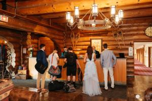 Una novia y un novio parados en un bar en una cabaña de madera en Le Grand Lodge Mont Tremblant en Mont-Tremblant