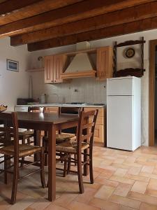 a kitchen with a table and a white refrigerator at Agriturismo Prato Grande in Loiano