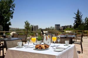 a table with a plate of food and glasses of orange juice at Leonardo Plaza Hotel Jerusalem in Jerusalem