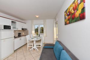 a living room with a kitchen and a table with a blue couch at Villa Gravic in Zadar