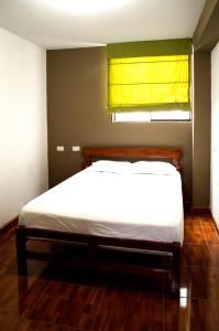 Bett in einem Schlafzimmer mit gelbem Fenster in der Unterkunft Hostal Los Angeles in Barranca