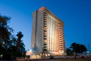 un edificio blanco alto con un letrero. en Leonardo Plaza Hotel Jerusalem, en Jerusalén