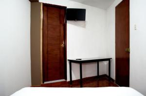 a bedroom with a bed and a table and a door at Hostal Los Angeles in Barranca +8 photos