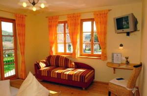 a living room with a couch and windows at Weingut Winzerhof Gästezimmer Grebenz in Großklein